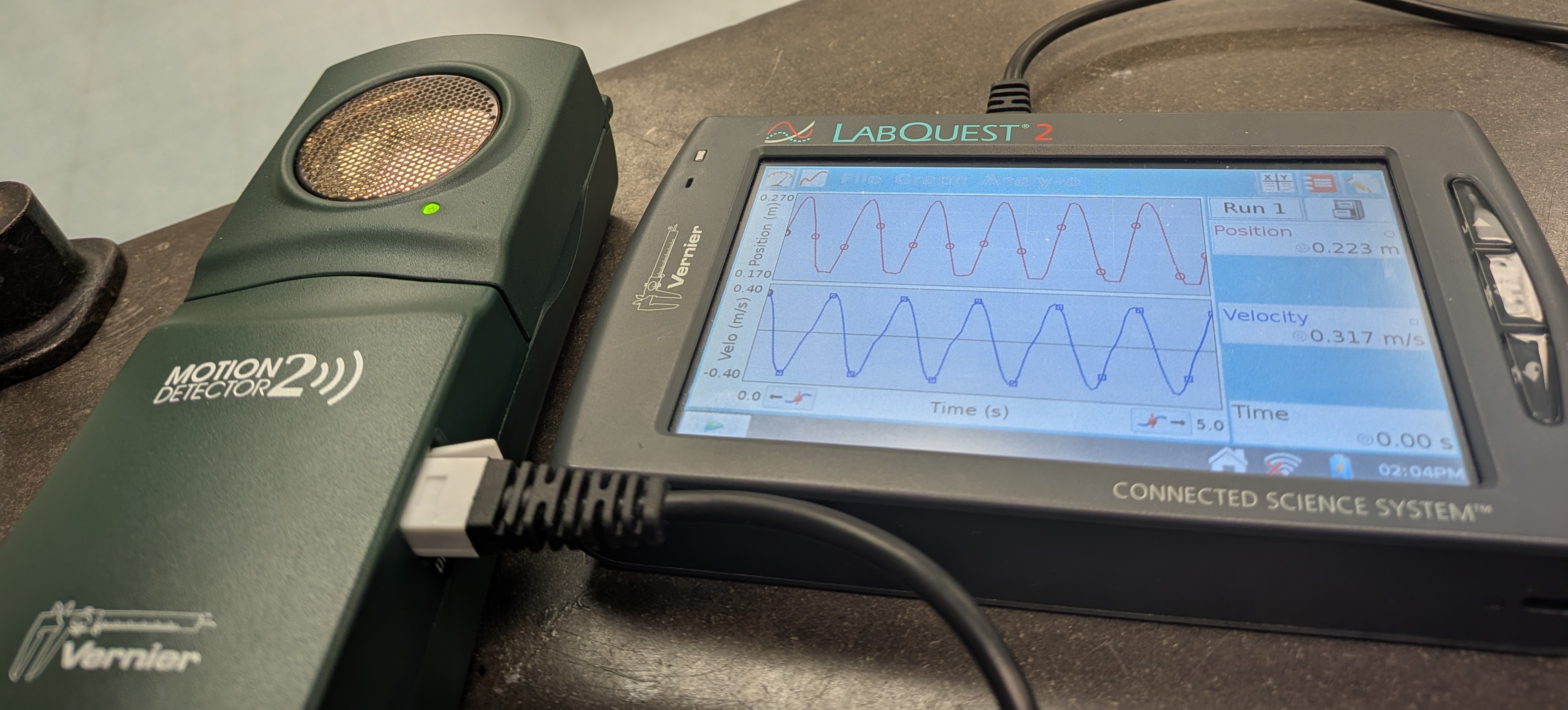 A Vernier motion decector and LabQuest showing position and velocity data
